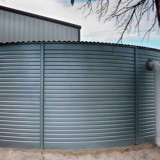 Large,Rain,Water,Tank,,Ecology,Friendly,,In,Front,Of,Metallic Large rain water tank, ecology friendly, in front of metallic building.